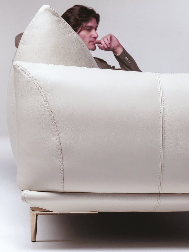 DRAGÉES Elegant sectional with heightened backrests for superior comfort, minimal base, and decorative stitching, combining sophistication with supported relaxation.